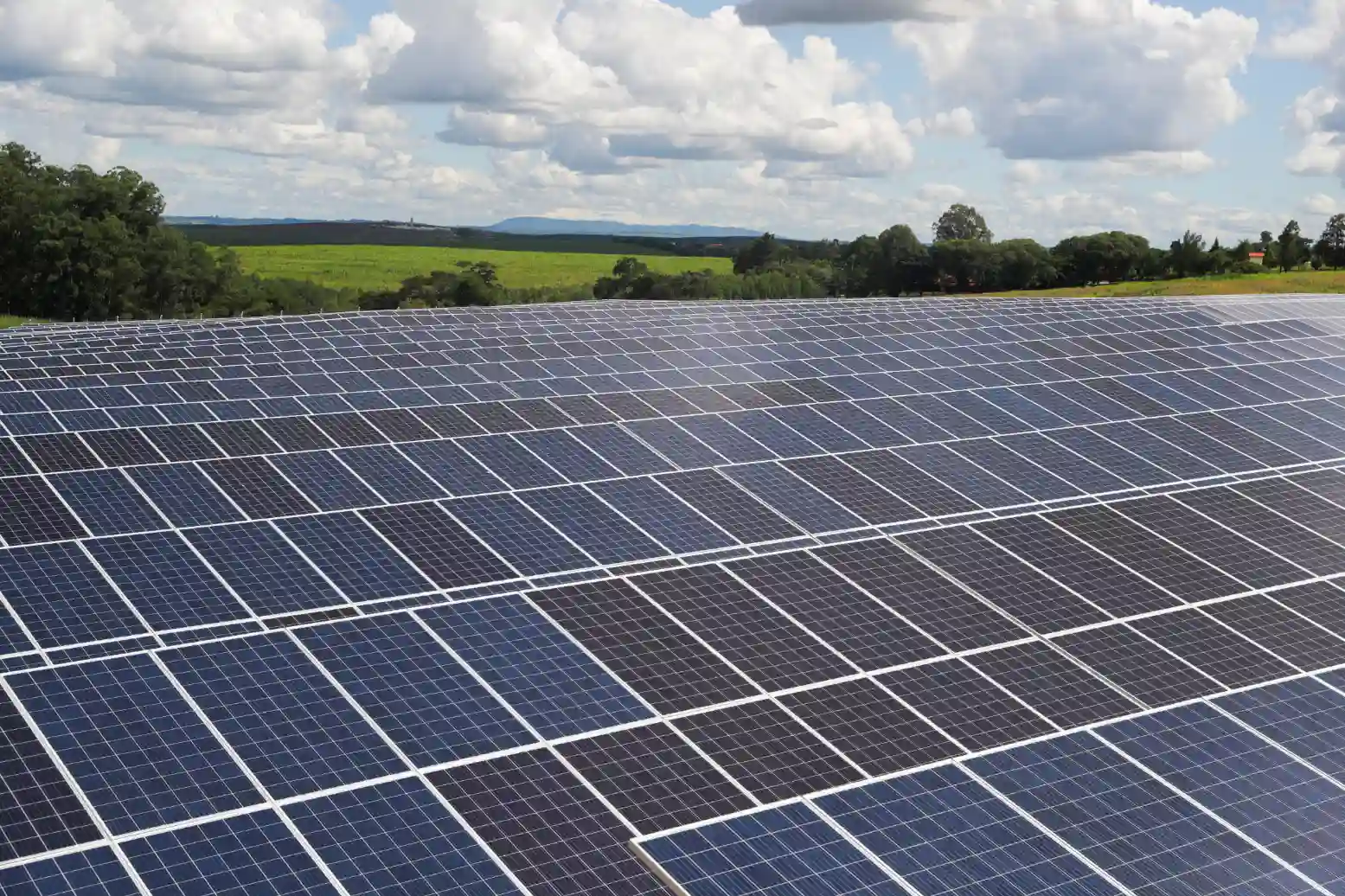 Painéis solares instalados em uma fazenda solar ao ar livre, aproveitando a energia solar para geração de energia limpa e sustentável.
