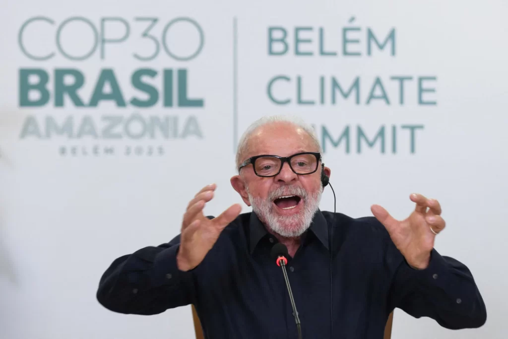Palestrante falando apaixonadamente na Conferência sobre o Clima na Amazônia, durante o Clima Summit em Belém, com o logo do evento ao fundo.