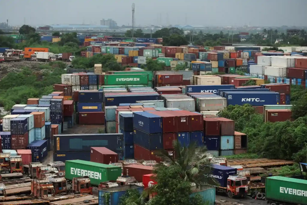Imagem de um grande carregamento de containers de navios e transporte terrestre, destacando a logística e transporte internacional. Cenas de movimentação de carga em porto ou ferrovias.