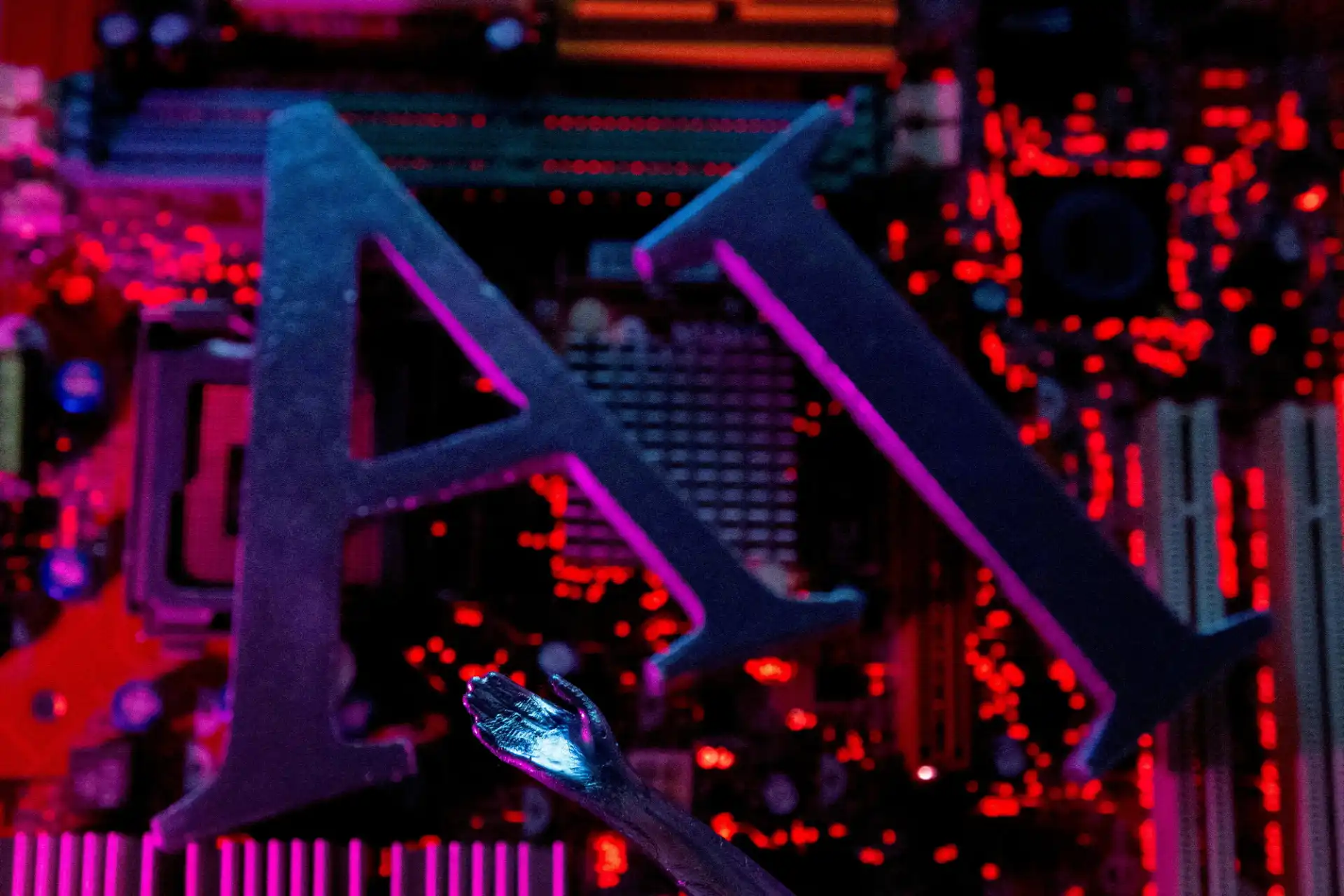 Imagem de um componente de computador, possivelmente uma placa-mãe, com iluminação em tons de vermelho e roxo, destacando letras 'A' e 'R' em destaque.